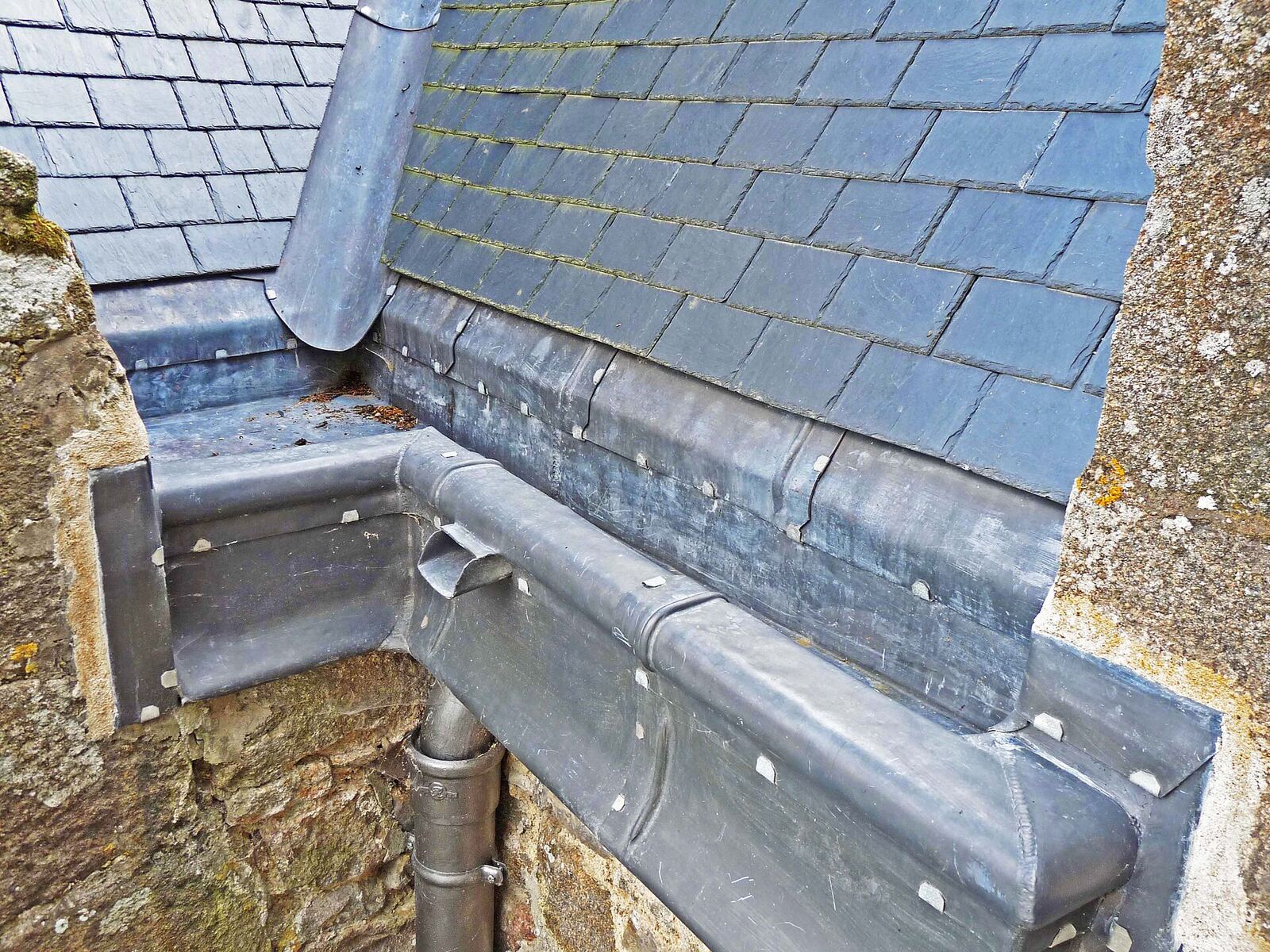 Rinne und Ablaufrohr aus Metall am Dachrand